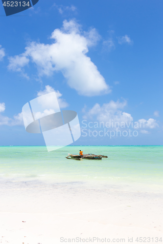 Image of Fishing boat on picture perfect white sandy beach with turquoise blue sea, Paje, Zanzibar, Tanzania.