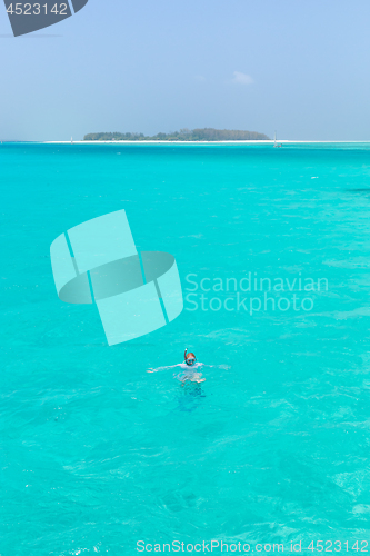 Image of Woman snorkeling in clear shallow sea of tropical lagoon with turquoise blue water.