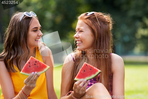 Image of teenage girls eating watermelon at picnic in park