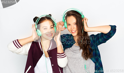 Image of teenage girls in earphones listening to music