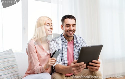 Image of couple with tablet pc and credit card at home