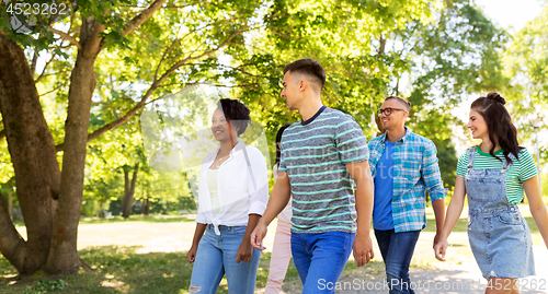 Image of happy international friends walking in park