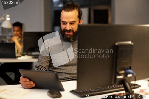 Image of creative man with computer working late at office