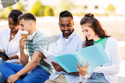 Image of international students with notebooks outdoors