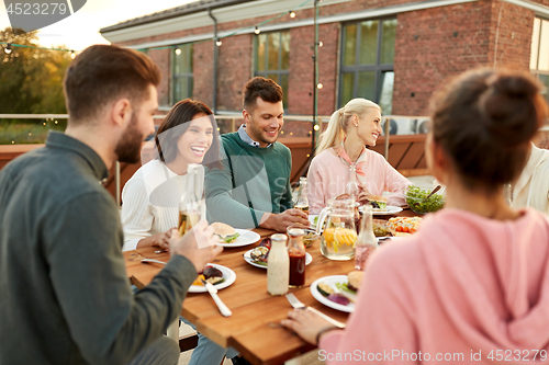 Image of friends having dinner or rooftop party in summer