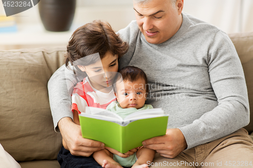 Image of happy father with sons reading book at home