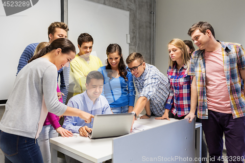 Image of students and teacher with laptop at school