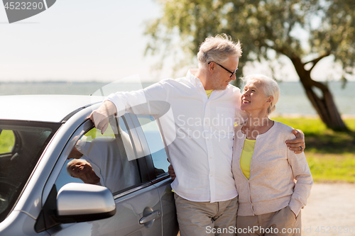 Image of happy senior couple with car in summer