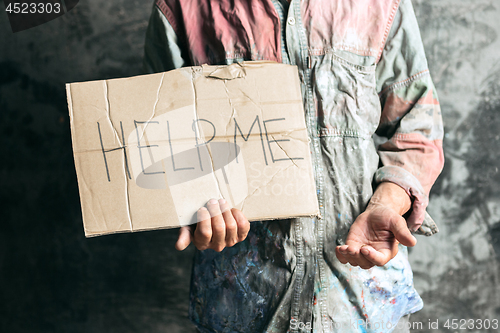 Image of Male beggar hands seeking money on the wooden floor at public path way