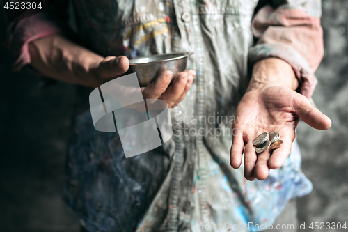 Image of Male beggar hands seeking money on the wooden floor at public path way