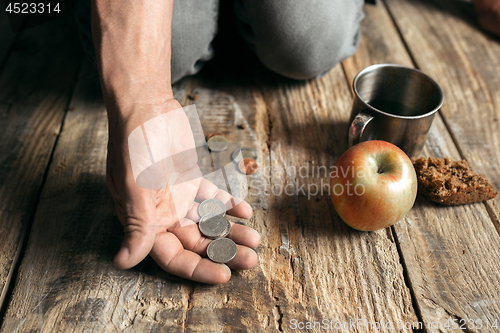 Image of Male beggar hands seeking food or money at public path way