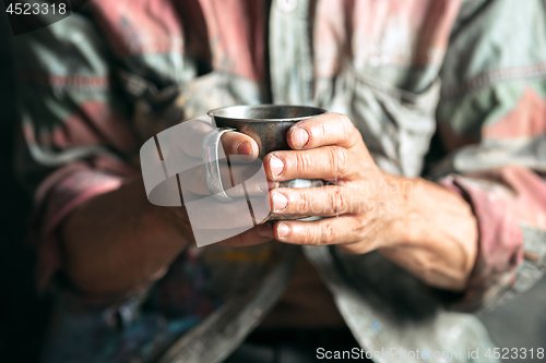 Image of Male beggar hands seeking food or money at public path way