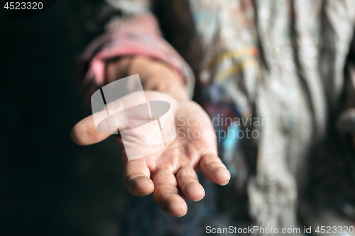 Image of Male beggar hands seeking money on the wooden floor at public path way