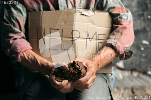 Image of Male beggar hands seeking money on the wooden floor at public path way