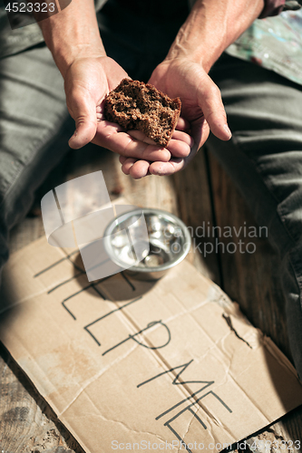 Image of Male beggar hands seeking money on the wooden floor at public path way