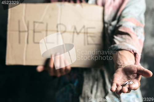 Image of Male beggar hands seeking money on the wooden floor at public path way