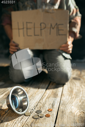 Image of Male beggar hands seeking money on the wooden floor at public path way