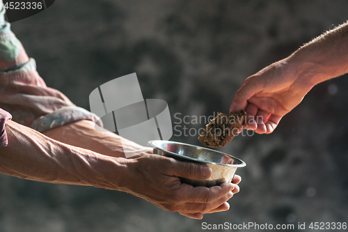 Image of Male beggar hands seeking food or money at public path way