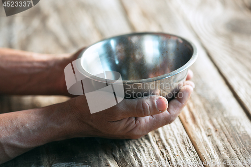 Image of Male beggar hands seeking money on the wooden floor at public path way