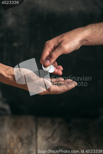 Image of Male beggar hands seeking money on the wooden floor at public path way