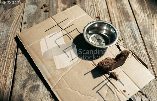 Image of Male beggar hands seeking money on the wooden floor at public path way