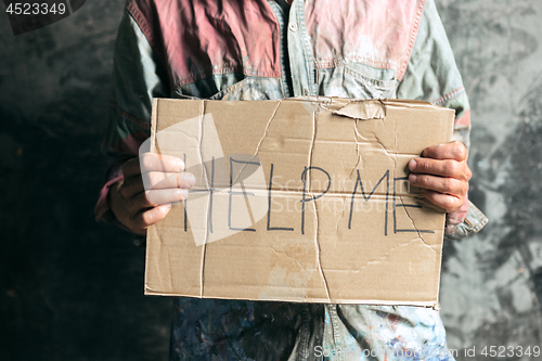 Image of Male beggar hands seeking money on the wooden floor at public path way