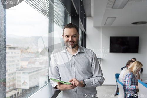 Image of Businessman Using Tablet In Office Building by window