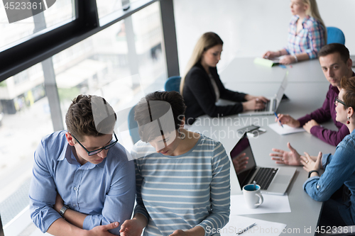 Image of Two Business People Working With Tablet in office