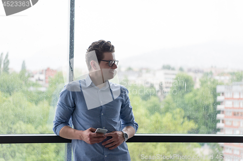 Image of Businessman Standing In A Modern Building Near The Window With P