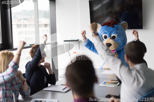 Image of boss dresed as bear having fun with business people in trendy of