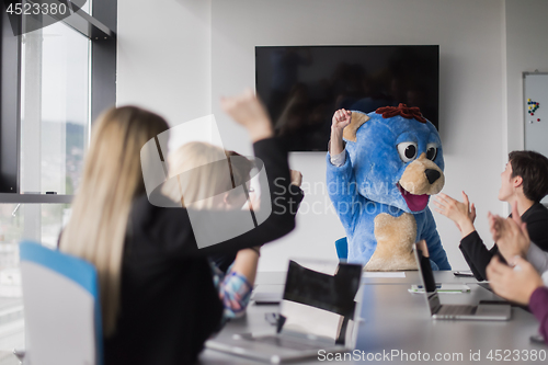 Image of boss dresed as bear having fun with business people in trendy of