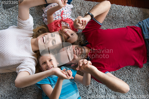 Image of happy family lying on the floor