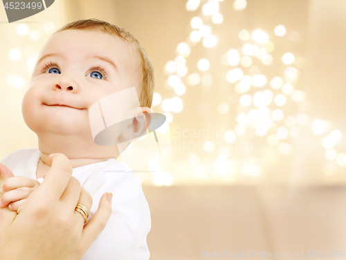 Image of close up of sweet baby over christmas lights