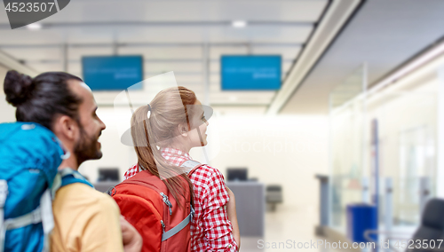 Image of couple of tourists with backpacks over airport