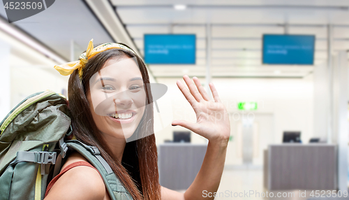 Image of young woman with backpack over airport terminal