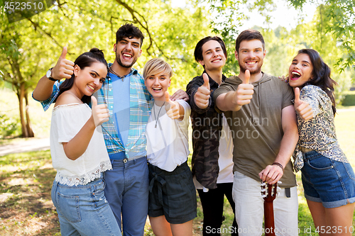 Image of friends with guitar showing thumbs up at park