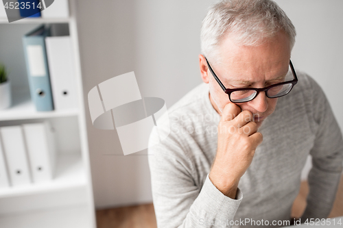 Image of close up of senior man in glasses thinking