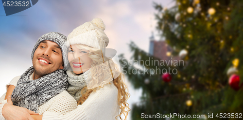 Image of happy couple hugging over christmas tree