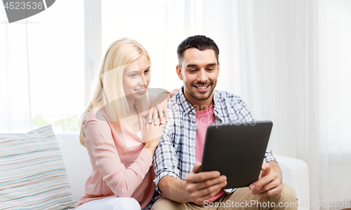 Image of happy couple with tablet computer at home