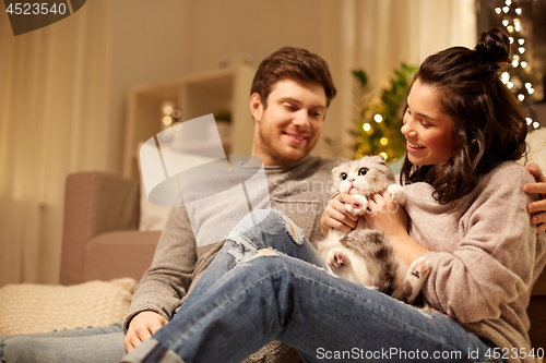 Image of happy couple with cat at home