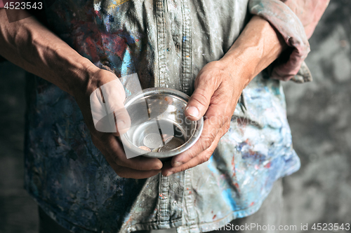 Image of Male beggar hands seeking food or money at public path way