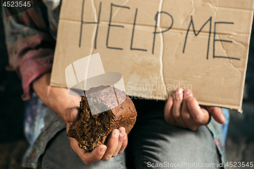 Image of Male beggar hands seeking money on the wooden floor at public path way