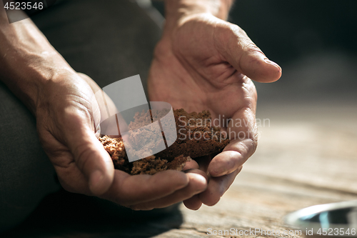 Image of Male beggar hands seeking food or money at public path way