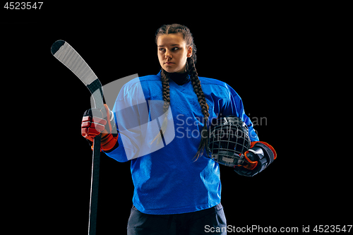 Image of Young female hockey player with the stick isolated on black background