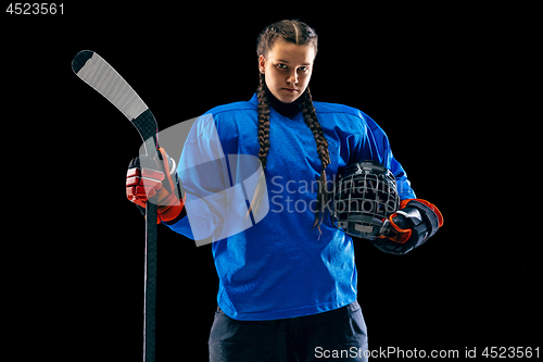 Image of Young female hockey player with the stick isolated on black background