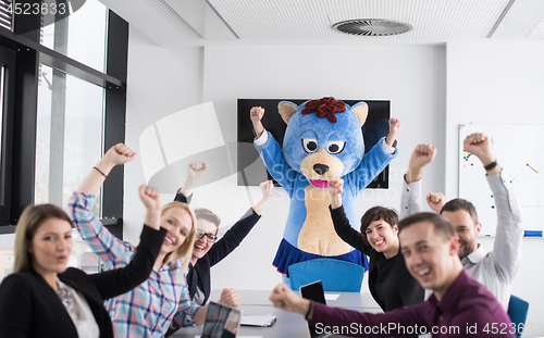 Image of boss dresed as bear having fun with business people in trendy of