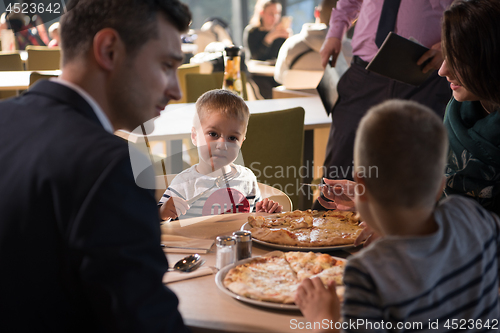 Image of Young parents enjoying lunch time with their children