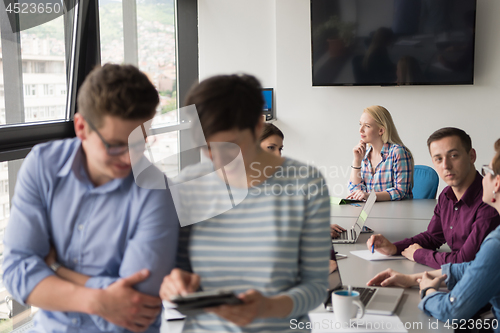 Image of Two Business People Working With Tablet in office