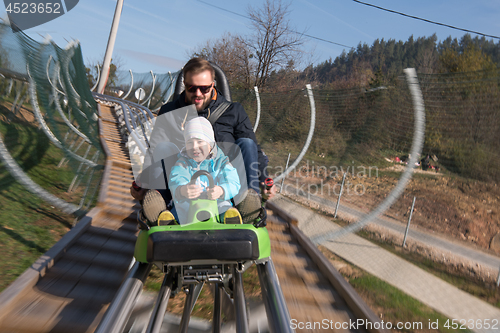 Image of father and son enjoys driving on alpine coaster