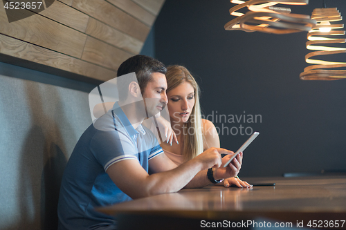 Image of couple using tablet at home